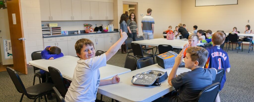 Child giving thumbs up in classroom